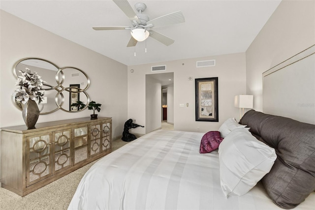 carpeted bedroom with ceiling fan with notable chandelier