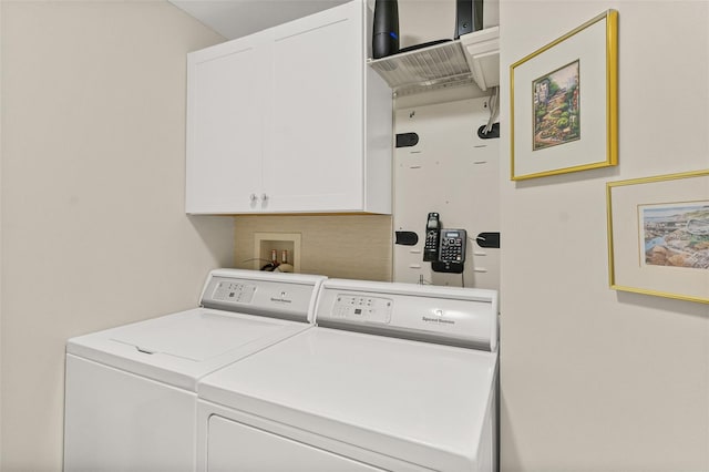 clothes washing area with cabinets and independent washer and dryer