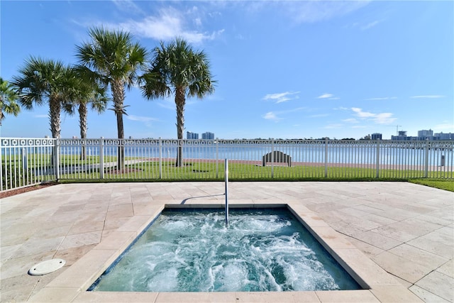 view of swimming pool with an in ground hot tub and a water view