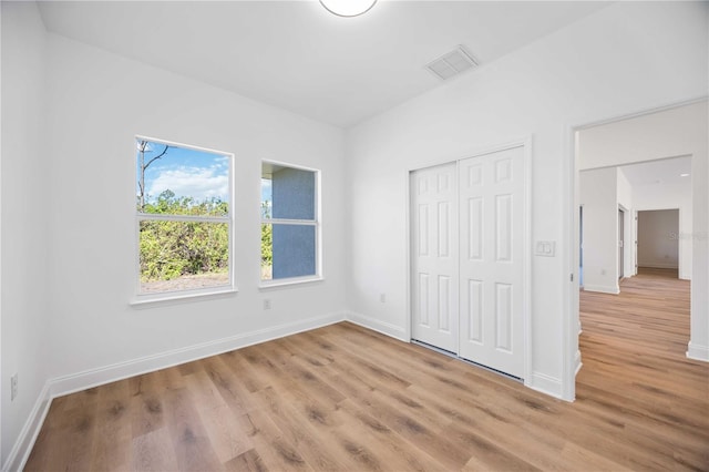 unfurnished bedroom featuring light wood-type flooring and a closet