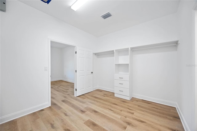 walk in closet with light hardwood / wood-style floors