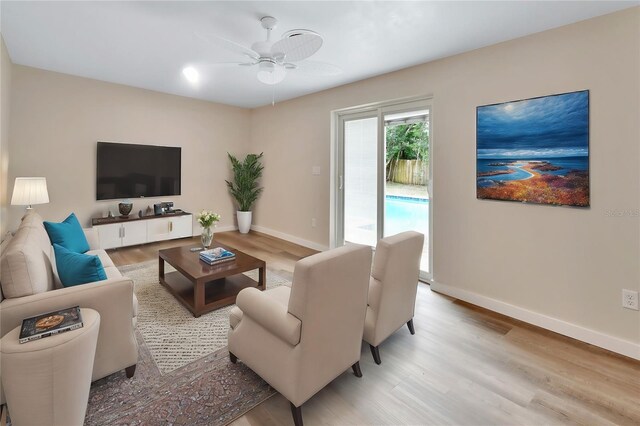 living room with ceiling fan and light hardwood / wood-style flooring