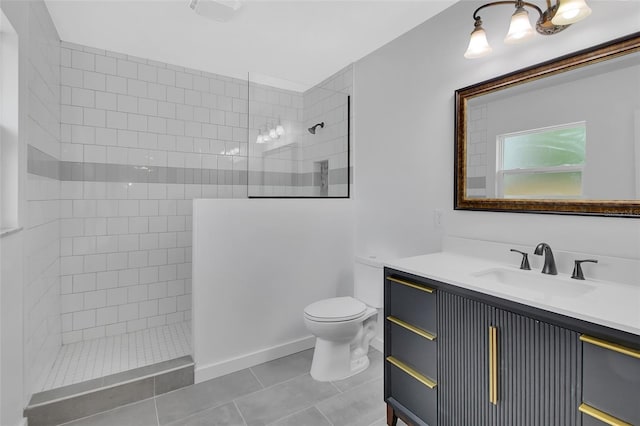 bathroom featuring tile patterned floors, toilet, vanity, and tiled shower