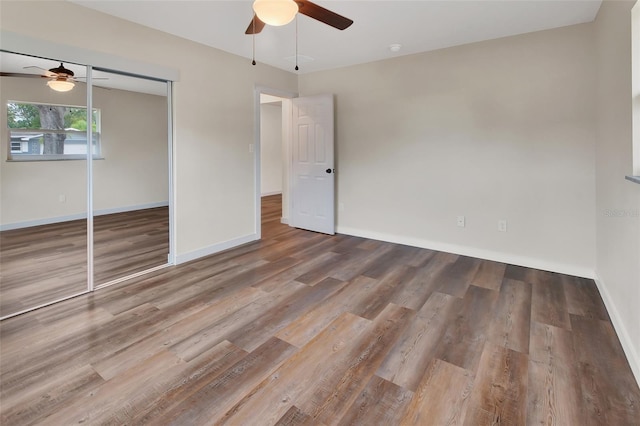 unfurnished bedroom with ceiling fan, a closet, and wood-type flooring