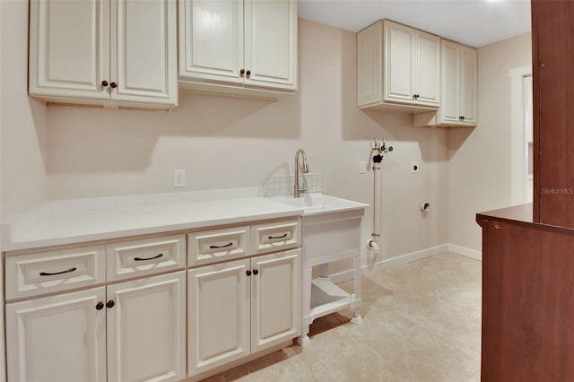 laundry room featuring electric dryer hookup, cabinets, hookup for a gas dryer, washer hookup, and light tile patterned floors