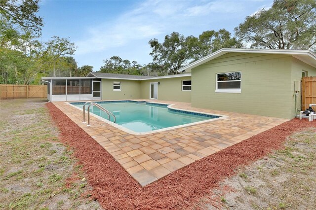 view of swimming pool featuring a patio area and a sunroom