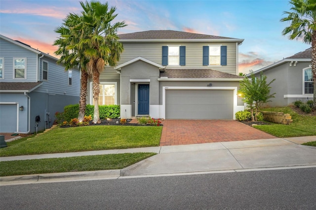 front of property featuring a garage and a yard