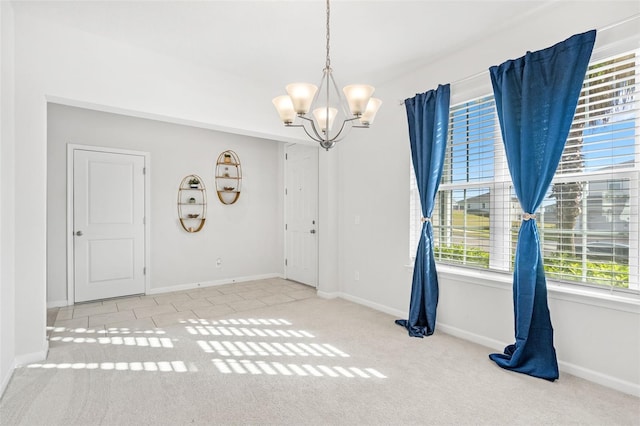 empty room featuring a notable chandelier and light colored carpet