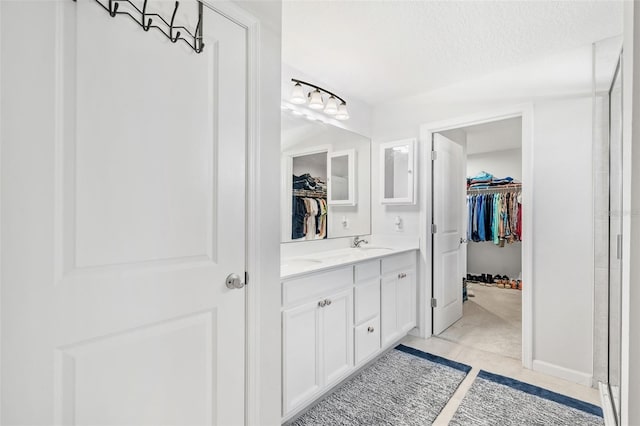 bathroom featuring tile patterned floors, vanity, and a textured ceiling