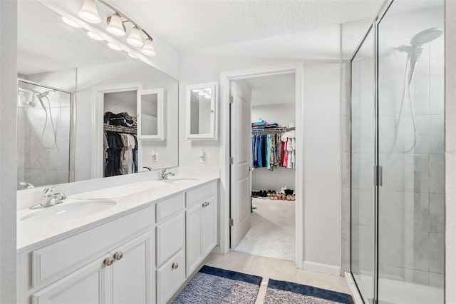 bathroom featuring a textured ceiling, tile patterned floors, vanity, and an enclosed shower