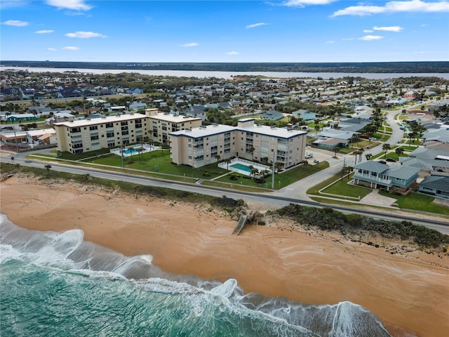 birds eye view of property featuring a beach view and a water view