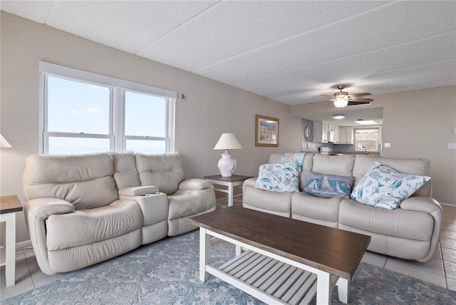 tiled living room featuring ceiling fan, sink, and a textured ceiling