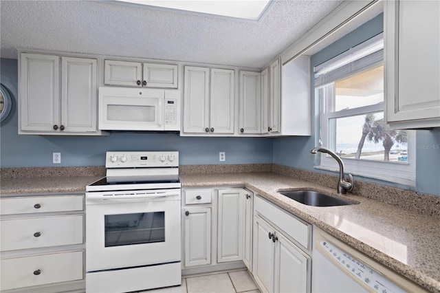 kitchen with white cabinetry, light tile patterned flooring, white appliances, and sink