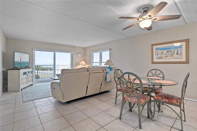 tiled dining room with a textured ceiling and ceiling fan