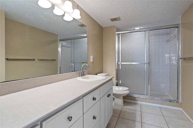 bathroom featuring tile patterned flooring, vanity, toilet, and walk in shower