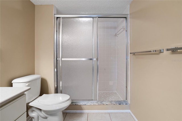 bathroom featuring tile patterned flooring, vanity, a shower with shower door, and a textured ceiling