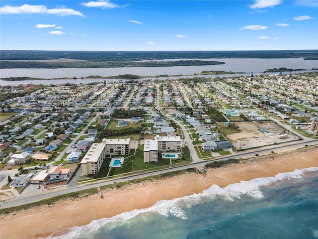 birds eye view of property featuring a beach view and a water view