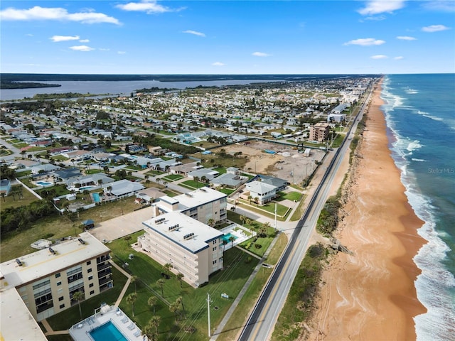 drone / aerial view featuring a water view and a view of the beach