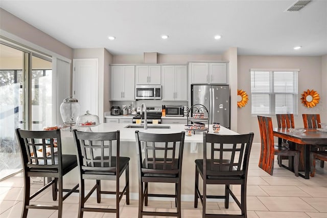 kitchen featuring a wealth of natural light, white cabinetry, sink, and appliances with stainless steel finishes