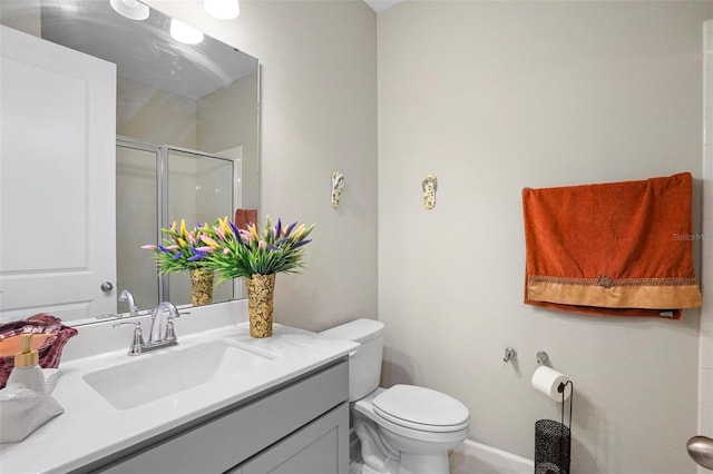 bathroom with vanity, toilet, and a shower with shower door