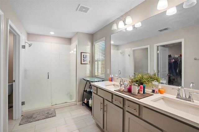 bathroom with vanity and a shower with door