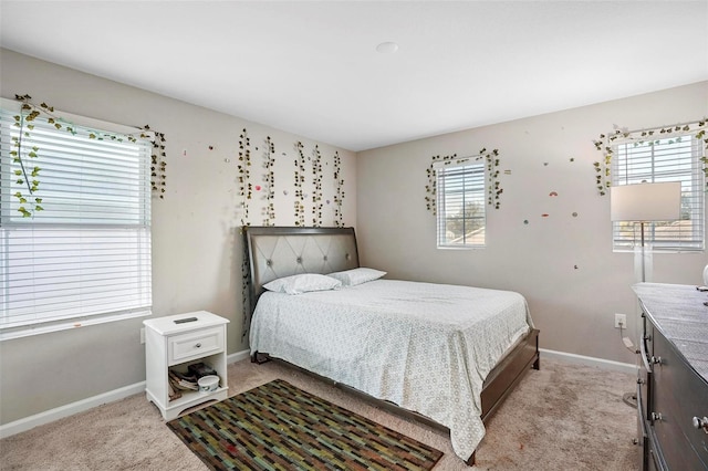 bedroom with multiple windows and light colored carpet