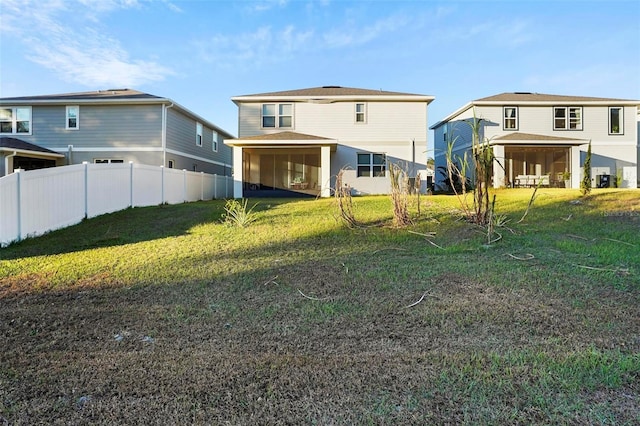 rear view of house featuring a lawn