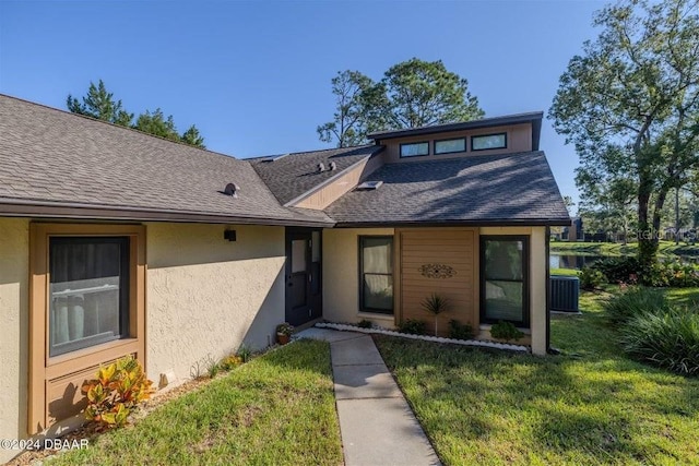 view of front of house with a front yard and central AC