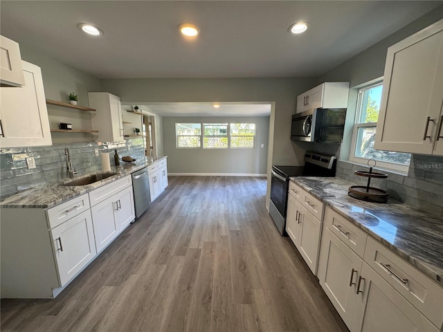 kitchen with hardwood / wood-style floors, appliances with stainless steel finishes, white cabinetry, and sink