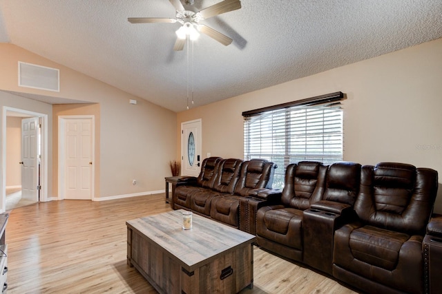 living room with a textured ceiling, light hardwood / wood-style flooring, ceiling fan, and lofted ceiling