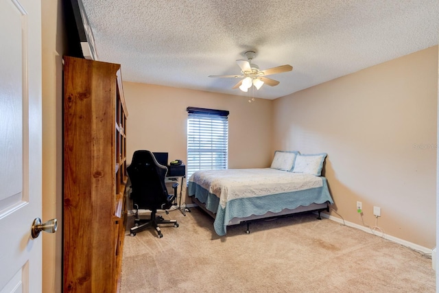 carpeted bedroom with ceiling fan and a textured ceiling