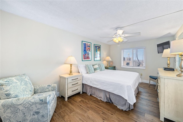 bedroom featuring ceiling fan, wood-type flooring, and a textured ceiling