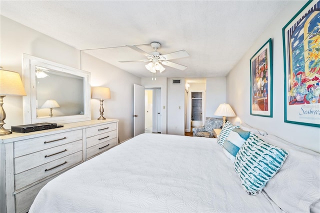 bedroom with ceiling fan and a textured ceiling