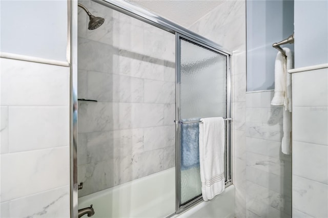 bathroom featuring bath / shower combo with glass door