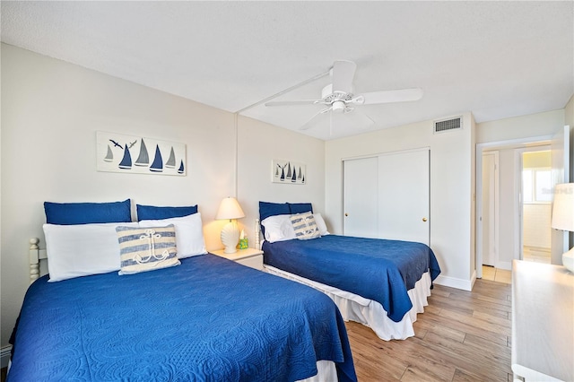 bedroom with ceiling fan, a closet, and hardwood / wood-style flooring