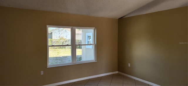 empty room featuring tile patterned floors, a mountain view, and a textured ceiling