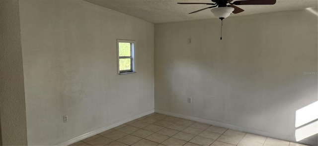 empty room with ceiling fan and light tile patterned floors