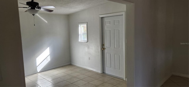 unfurnished room featuring a textured ceiling, ceiling fan, and light tile patterned flooring