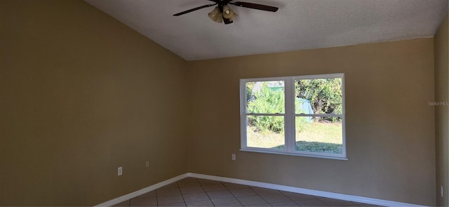 empty room with tile patterned flooring, a textured ceiling, ceiling fan, and lofted ceiling