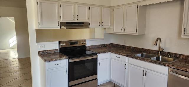 kitchen with appliances with stainless steel finishes, extractor fan, sink, white cabinets, and light tile patterned flooring