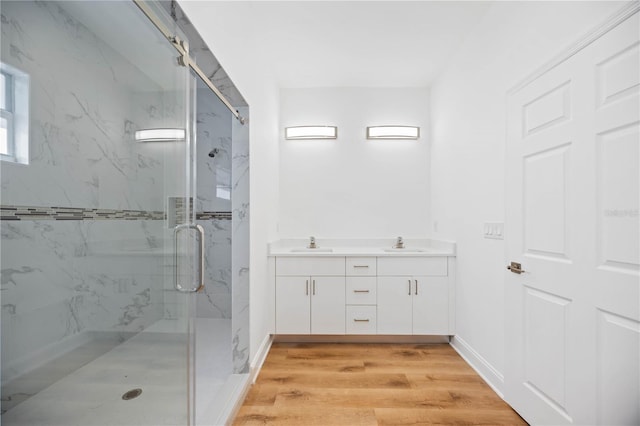 bathroom with hardwood / wood-style floors, vanity, and a shower with shower door