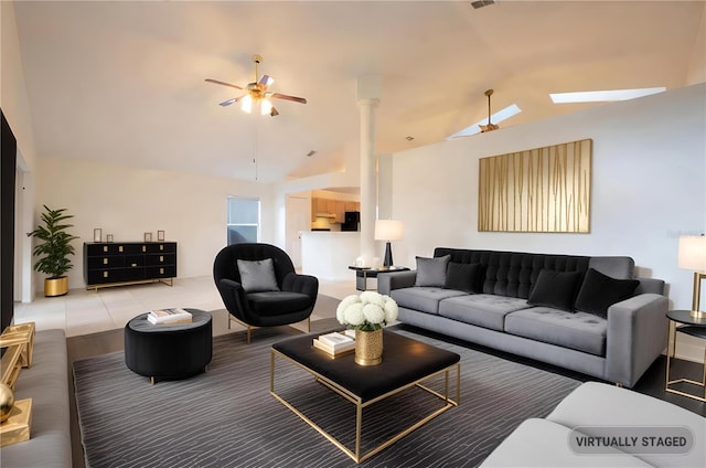 living room featuring ceiling fan, light tile patterned floors, and vaulted ceiling