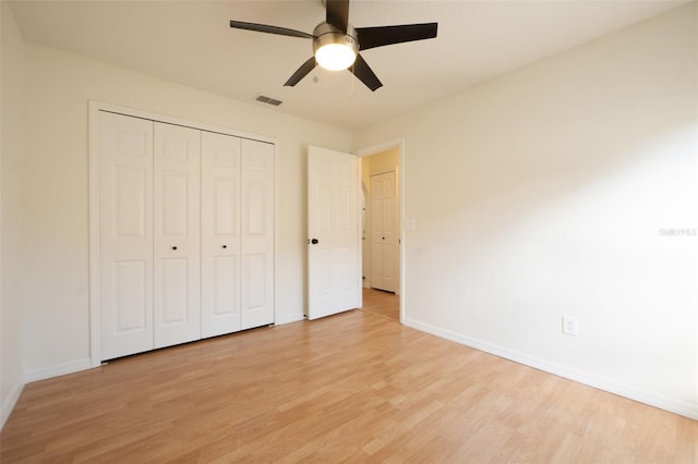 unfurnished bedroom featuring ceiling fan, light wood-type flooring, and a closet