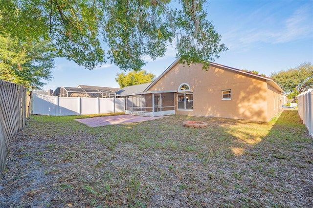 back of property featuring a sunroom, a yard, and a patio