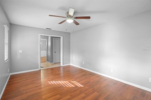 1195 Glen Royal Ter, Deland, FL 32720 - unfurnished bedroom with wood finished floors, baseboards, ceiling fan, and a textured ceiling