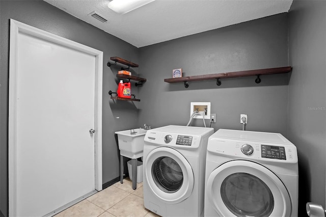1195 Glen Royal Ter, Deland, FL 32720 - laundry room with washer and clothes dryer, light tile patterned floors, and a textured ceiling