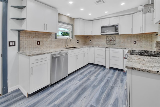 kitchen featuring white cabinetry, sink, appliances with stainless steel finishes, and light hardwood / wood-style flooring