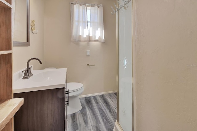 bathroom with vanity, hardwood / wood-style flooring, toilet, and an enclosed shower