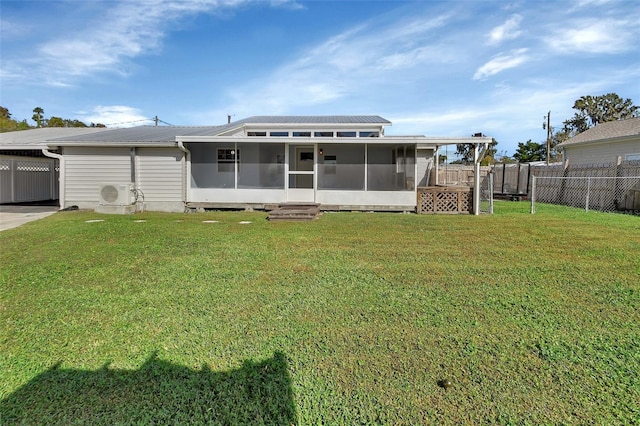 rear view of house with a lawn, a sunroom, and ac unit