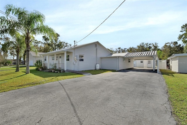 view of front of house featuring a carport and a front lawn